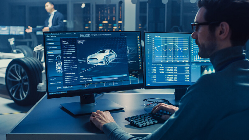 Foto von einem Konstrukteur, der mit CAD Komponenten für einen PKW entwickelt.