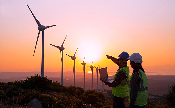 Zwei Mitarbeitende begutachten acht Windräder