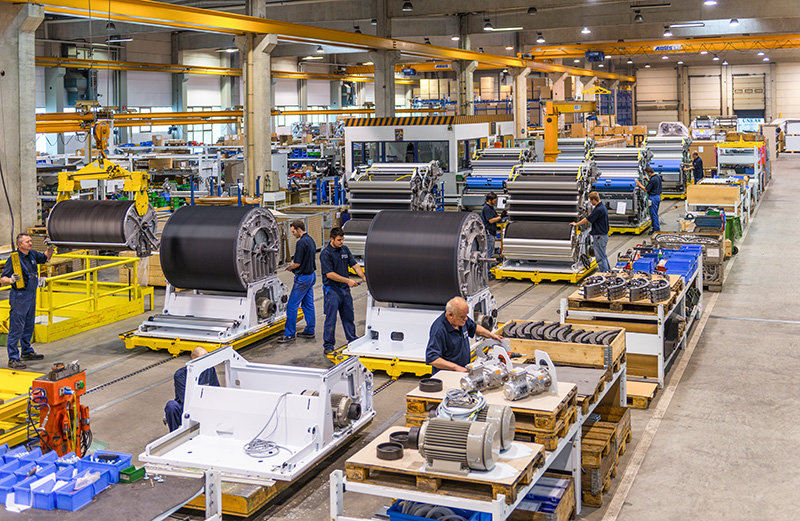 A large production hall where several workers assemble Trützschler machines.