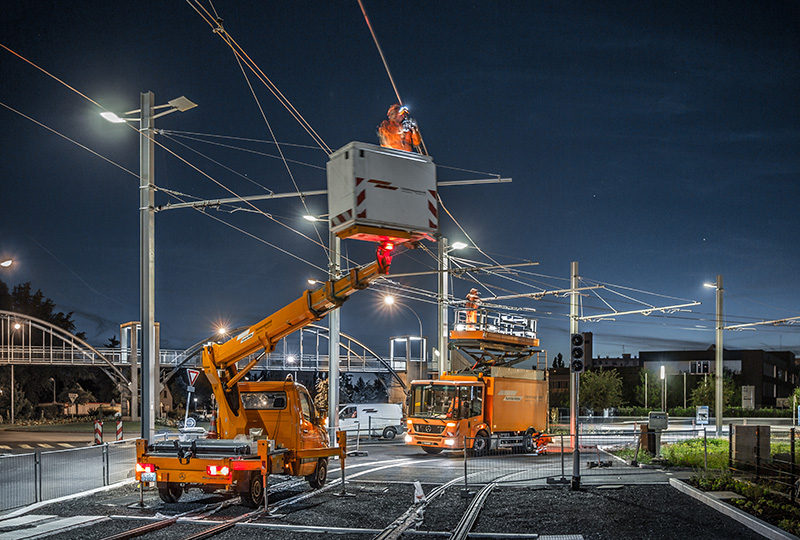 Nighttime maintenance work on a tram power catenary using Kummler+Matter work vehicles.